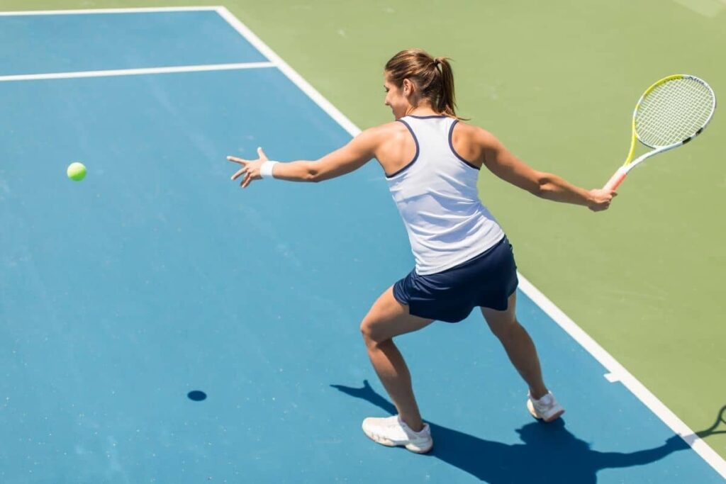 Side view of a girl in forehand motion and about to hit the ball.